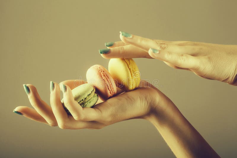 Θηλυκά χέρια με το macaron στοκ φωτογραφίες με δικαίωμα ελεύθερης χρήσης